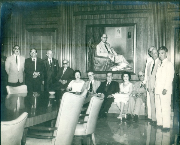 Foto de La directora de la BNJM Lilia Castro de Morales (quinta, de izquierda a derecha) y la Junta de Patronos en el Salón de conferencias, detrás, el cuadro en honor a Emeterio Santovenia, febrero de 1958. Colección BNJM.